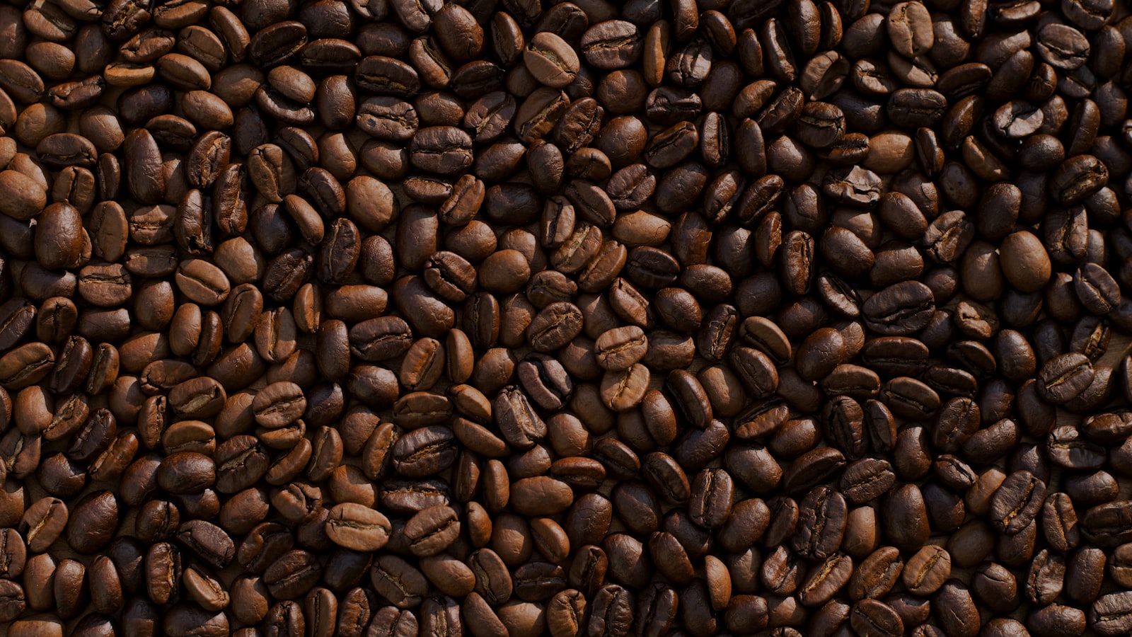 A warm mug of black coffee resting on a wooden table by a window.