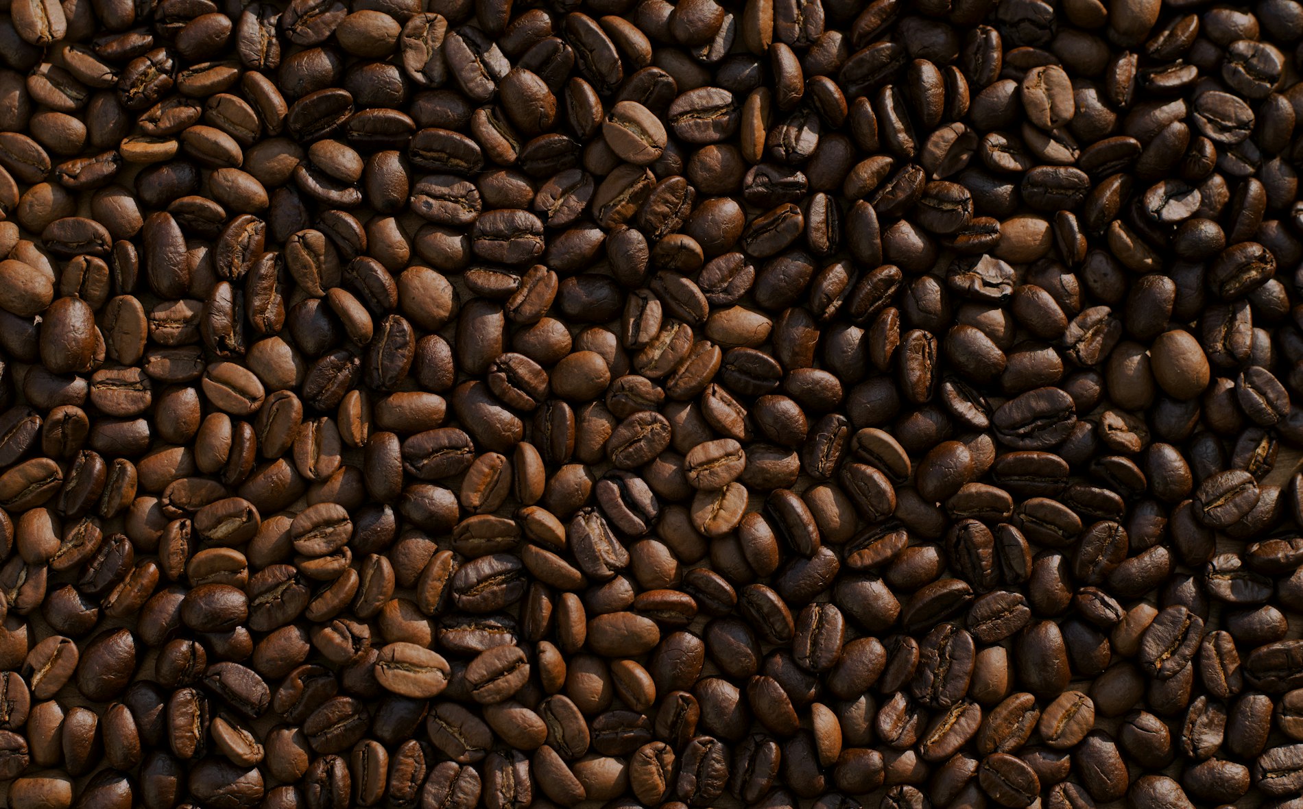 A warm mug of black coffee resting on a wooden table by a window.