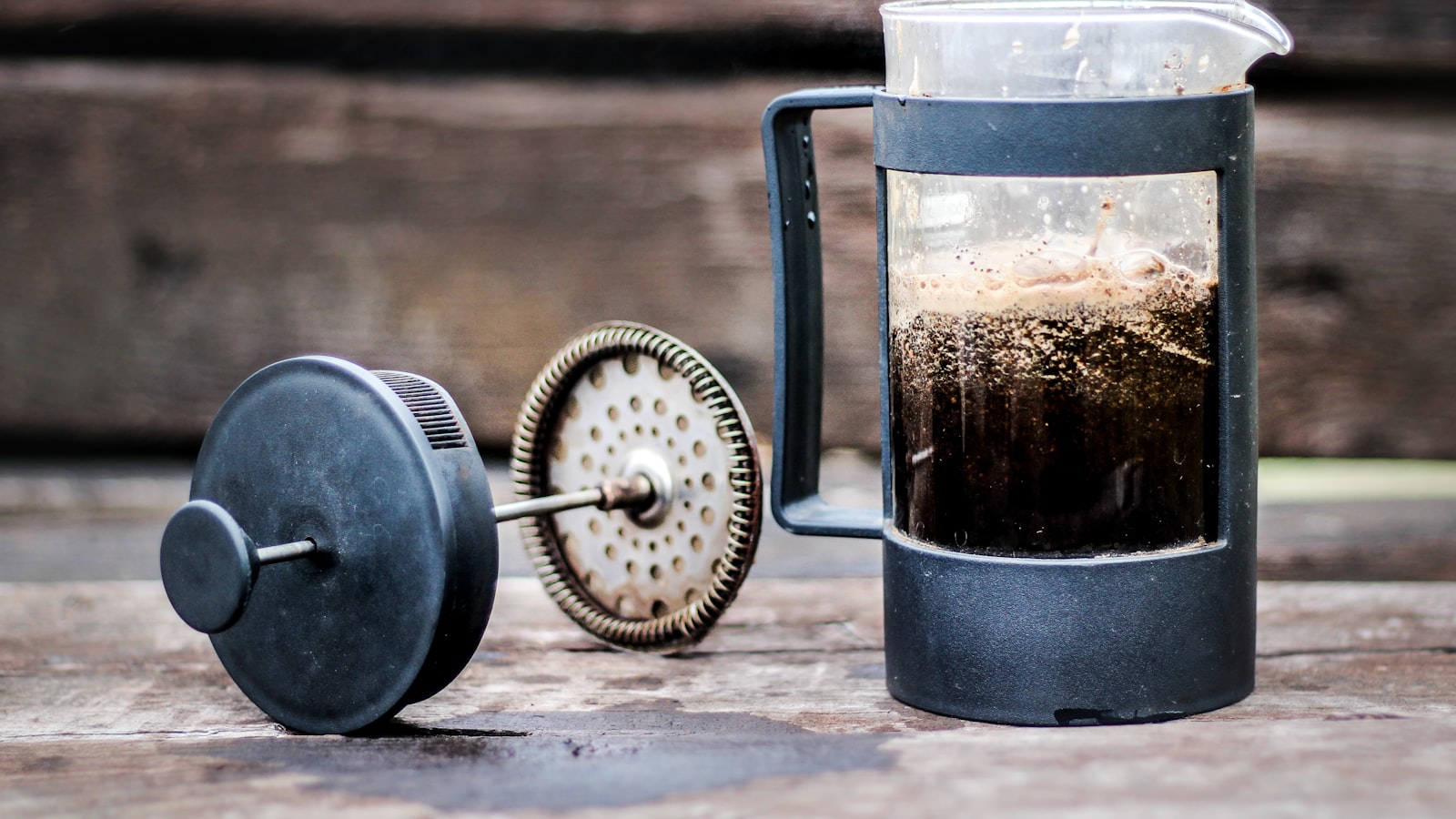 An espresso machine pulling a shot into a small cup with fresh crema on top.