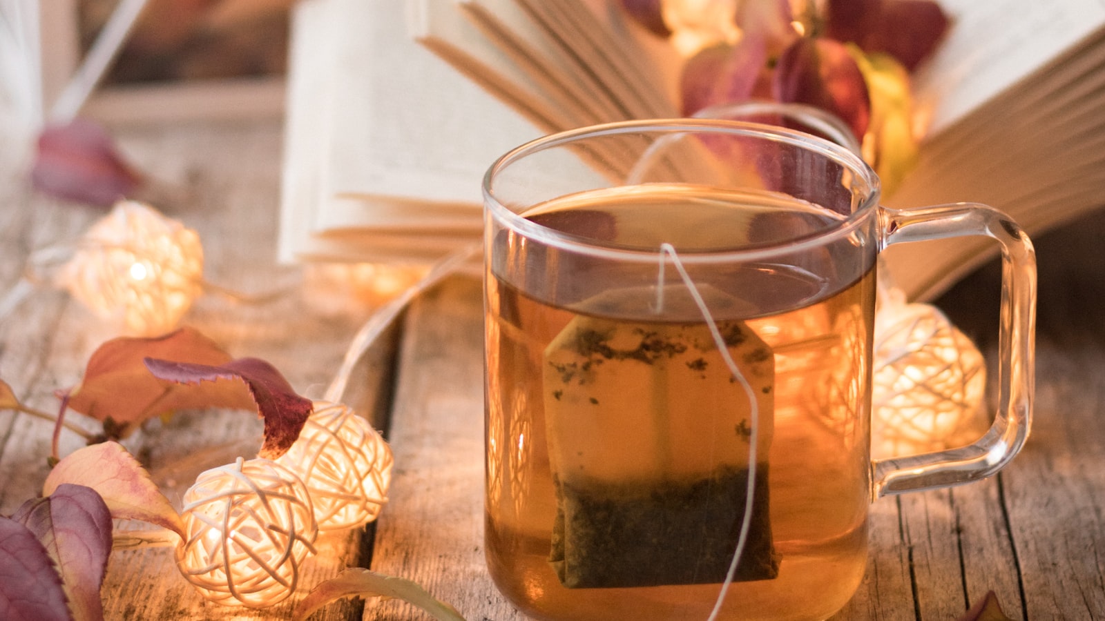 A cup of dark black tea on a wooden table